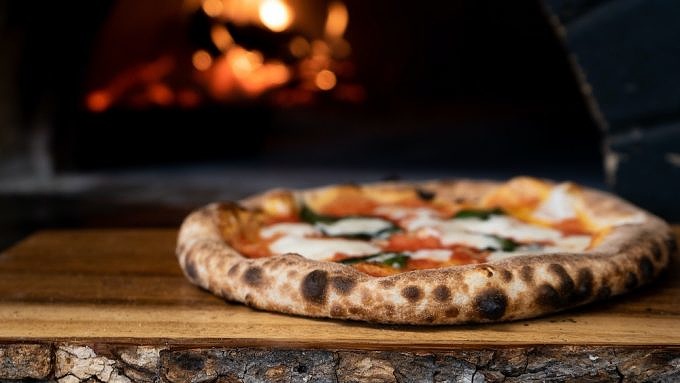 Neapolitanische Pizza vor einem Holzkohleofen